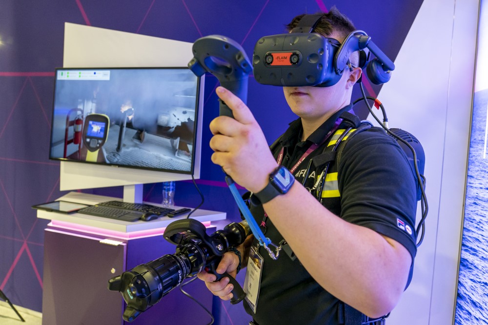 A trainee is fitted with a virtual reality headset and uses a handheld controller as he takes part in one of FLAIM’s immersive training solutions