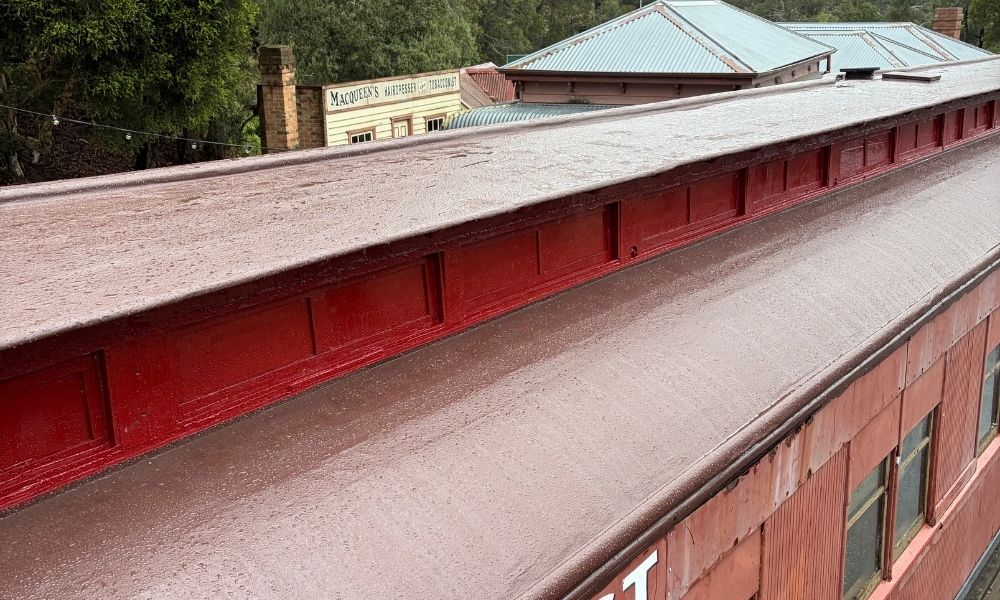 Birds-eye-view of the restored train carriage roof, which is now covered in finished brown and red wooden panelling.