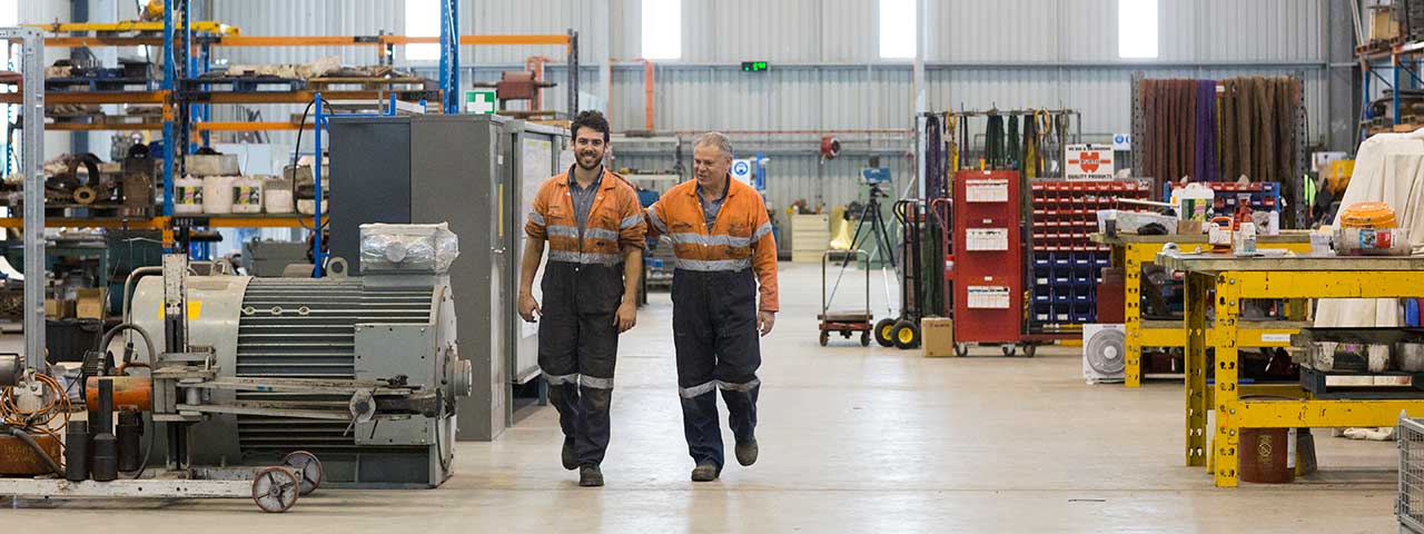 Two workers walking in factory