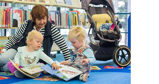 A woman playing with two small children