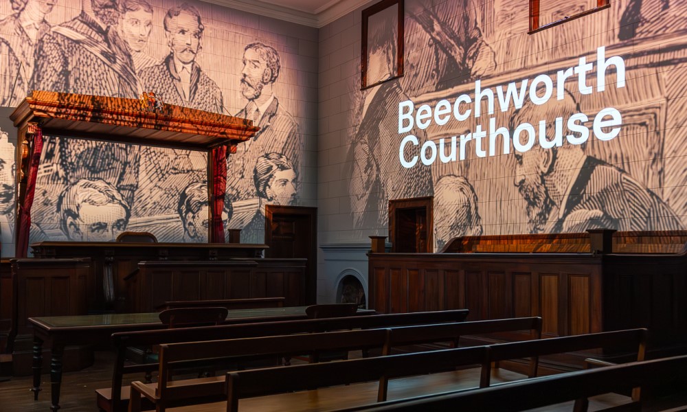 Old drawn image of court attendees projected onto walls of inside of old courthouse.