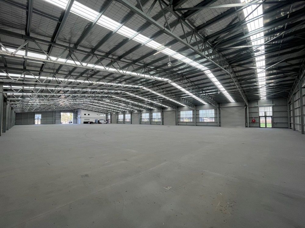 Interior facilities at the new Ballarat Showgrounds in Mount Rowan. A large indoor event space is visible, with grey floors, walls and ceilings and industrial lighting overhead.