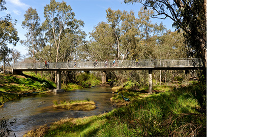 Bikes riding over wooden bridge on the O'Keef Rail Trail