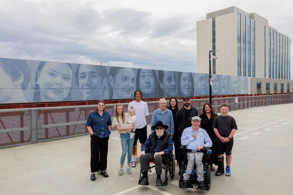 Artist Rone with some of the community members featured on the mural.