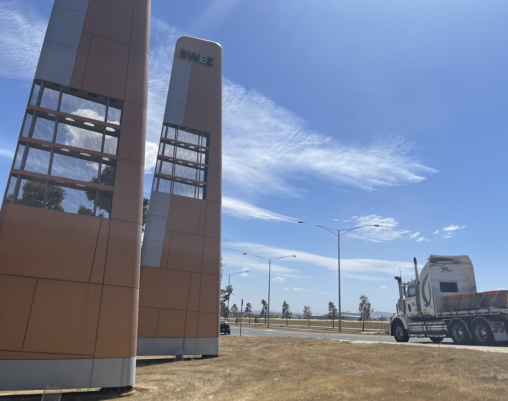 Two signs at the edge of the Ballarat West Employment Precinct, with a truck driving past on the adjacent road.