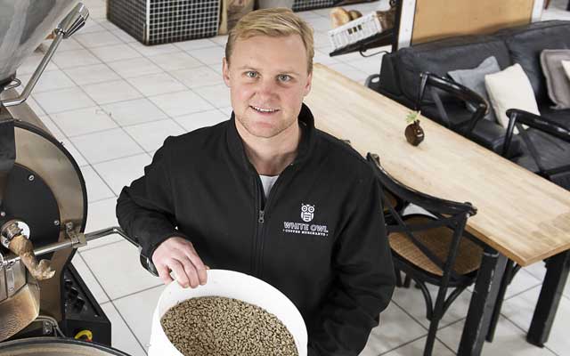 person preparing coffee beans for roasting