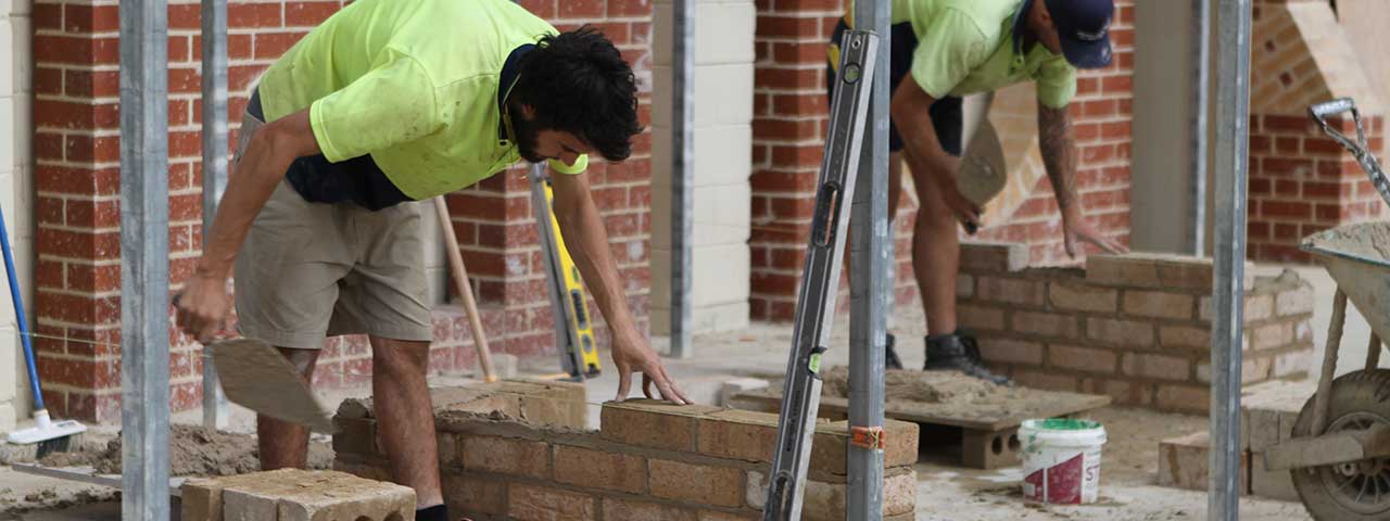 construction workers laying bricks