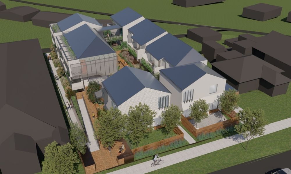 Render of the RWAF Woorayl Lodge project, showing a birds-eye view of 7 white buildings with blue roofs and accessible access points from the street via footpaths. The buildings are arranged around a central court, which has trees and garden beds. 